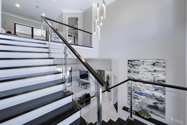 stairs with tile flooring and ornamental molding