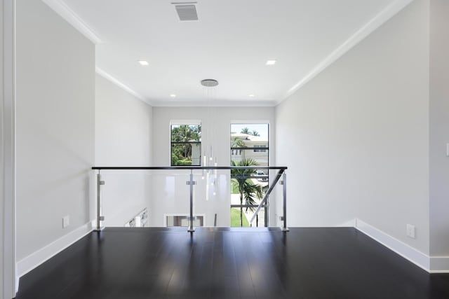 unfurnished room featuring ornamental molding and dark wood-type flooring