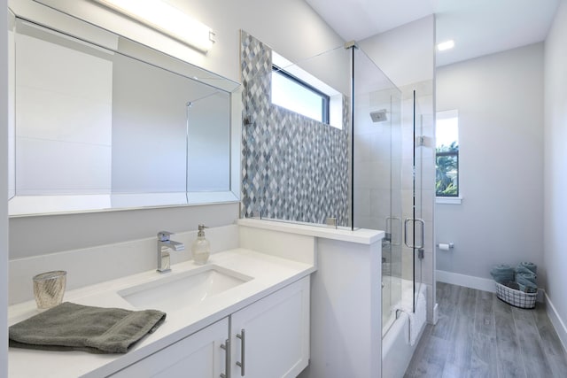 bathroom featuring plenty of natural light, vanity with extensive cabinet space, and wood-type flooring