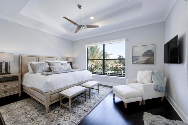 bedroom with ceiling fan, a raised ceiling, crown molding, and wood-type flooring