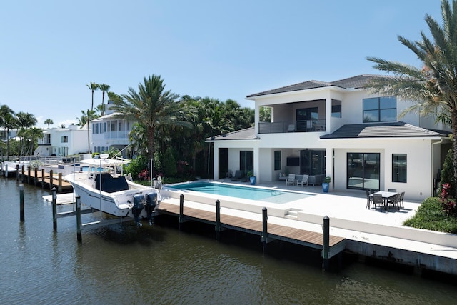 back of property featuring a patio area, a balcony, and a water view