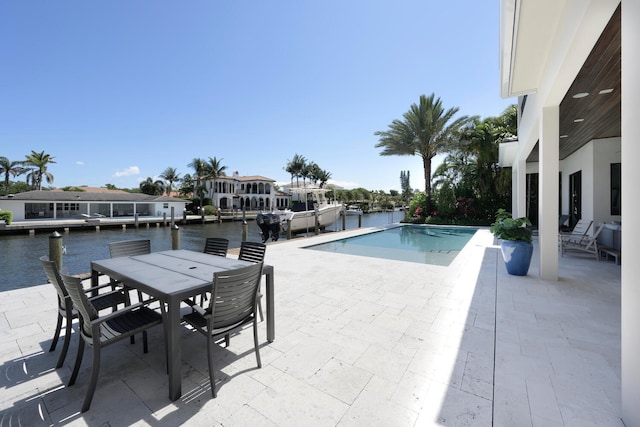 view of swimming pool featuring a dock, a water view, and a patio area