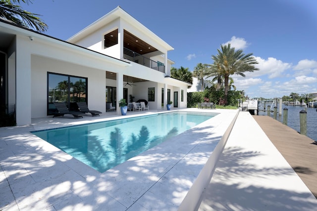 view of pool featuring a patio, an outdoor hangout area, ceiling fan, and a boat dock