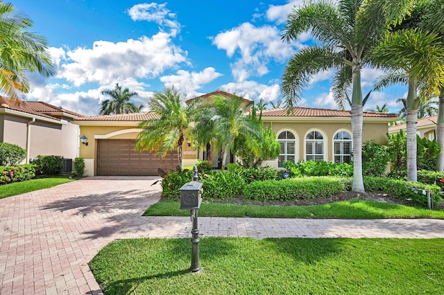 mediterranean / spanish-style home with a front yard and a garage