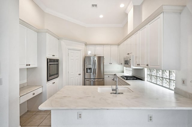 kitchen featuring light stone countertops, kitchen peninsula, appliances with stainless steel finishes, sink, and white cabinets