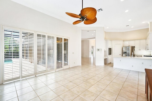 unfurnished living room featuring crown molding, light tile flooring, ceiling fan, and sink