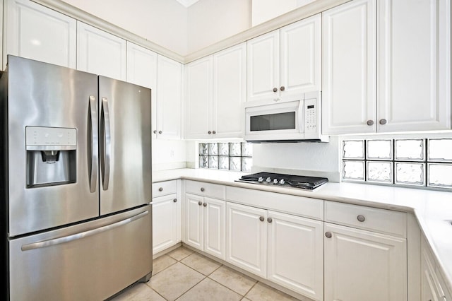 kitchen featuring white cabinets, appliances with stainless steel finishes, and light tile floors