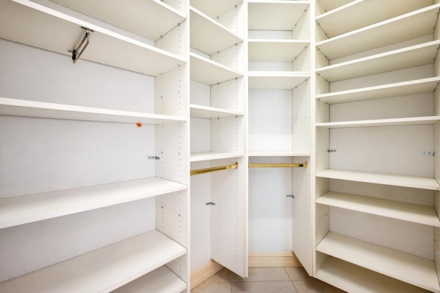 walk in closet featuring light tile flooring