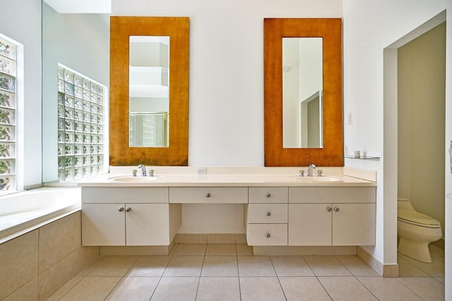 bathroom featuring tile floors, dual vanity, and tiled tub