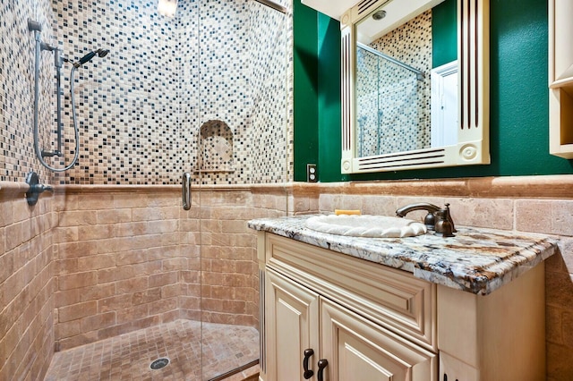 bathroom with backsplash, tile walls, walk in shower, and vanity