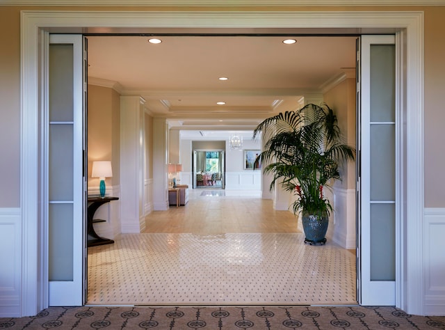 hall with light colored carpet and ornamental molding