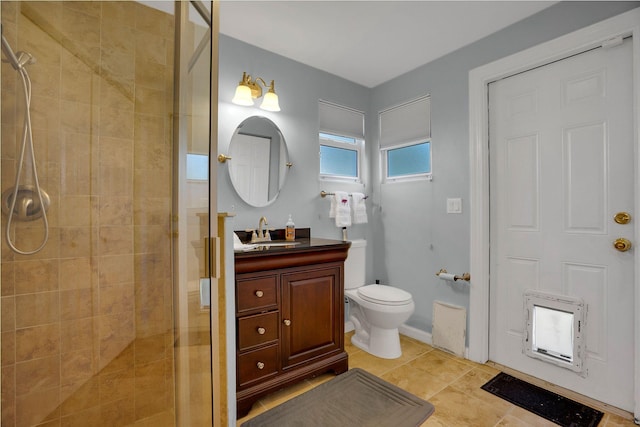 bathroom with vanity, tile flooring, toilet, and tiled shower