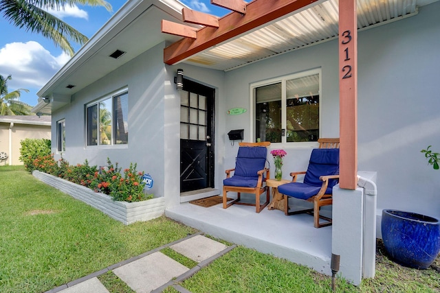 doorway to property featuring a lawn