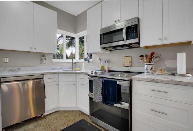 kitchen with sink, white cabinets, appliances with stainless steel finishes, and light stone counters