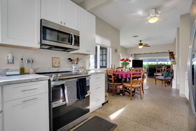 kitchen featuring light stone countertops, white cabinetry, ceiling fan, and stainless steel appliances