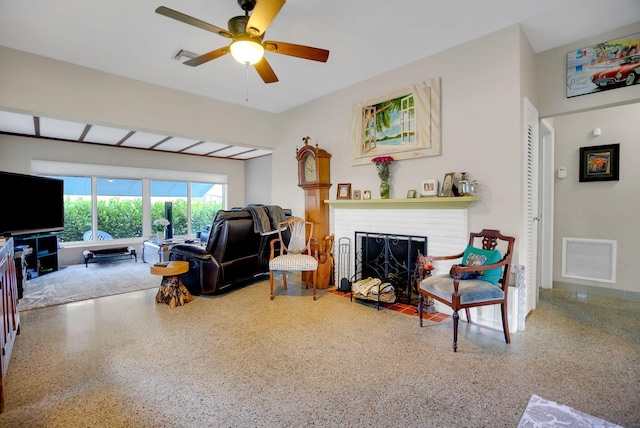 living room with ceiling fan and a brick fireplace