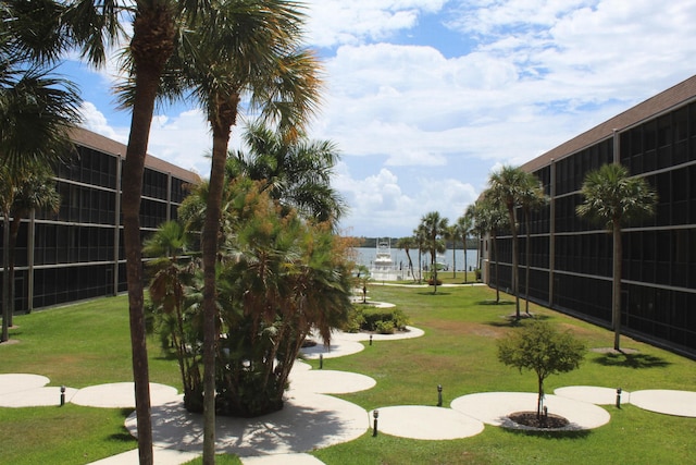 view of home's community featuring a water view and a lawn