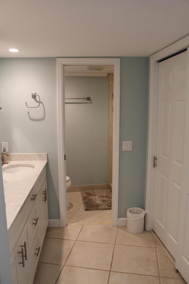 bathroom with toilet, vanity, and tile flooring