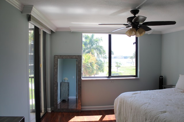 bedroom with ceiling fan, ornamental molding, and dark wood-type flooring