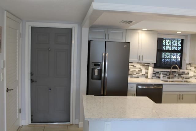 kitchen featuring tasteful backsplash, light tile floors, dishwasher, and stainless steel refrigerator with ice dispenser