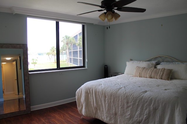 bedroom with crown molding, ceiling fan, and dark wood-type flooring