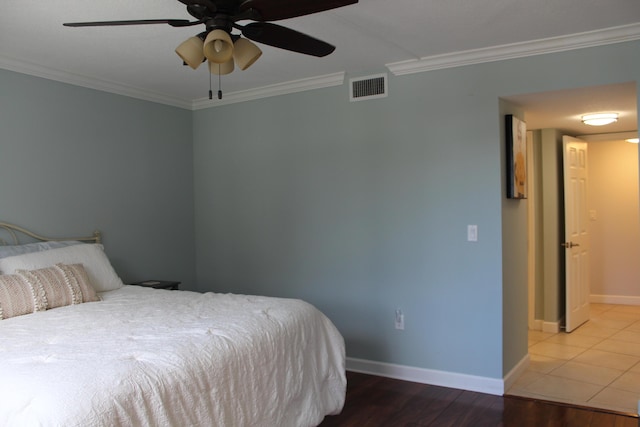 tiled bedroom with ceiling fan and crown molding