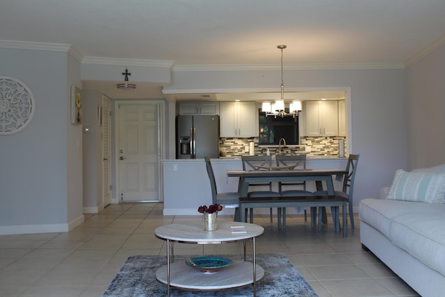 living room featuring light tile floors, a chandelier, and ornamental molding