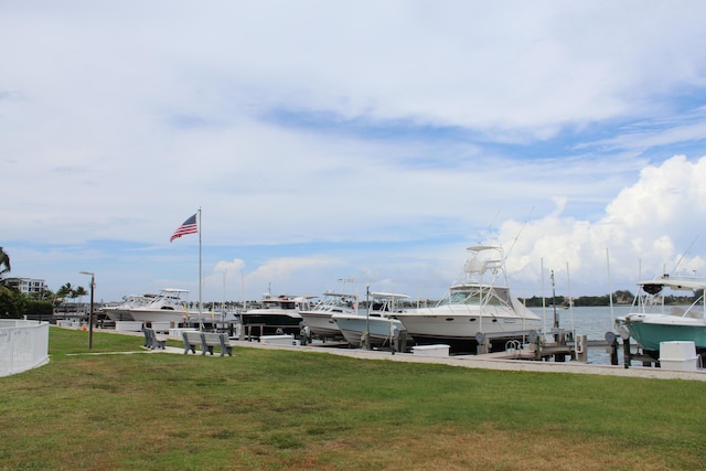 view of dock with a yard and a water view