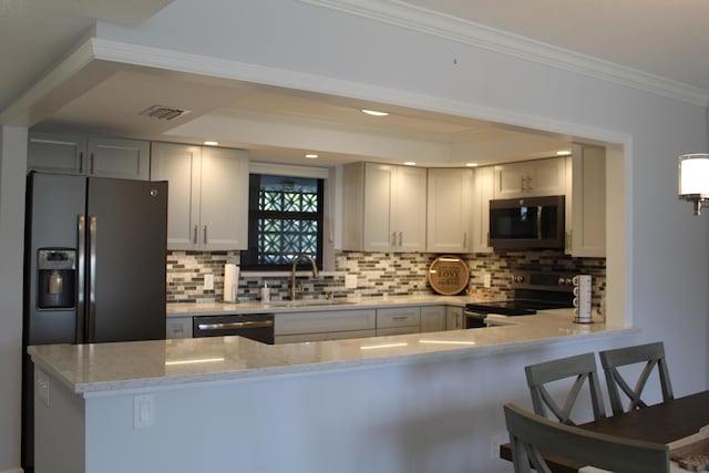 kitchen with sink, light stone counters, ornamental molding, appliances with stainless steel finishes, and backsplash