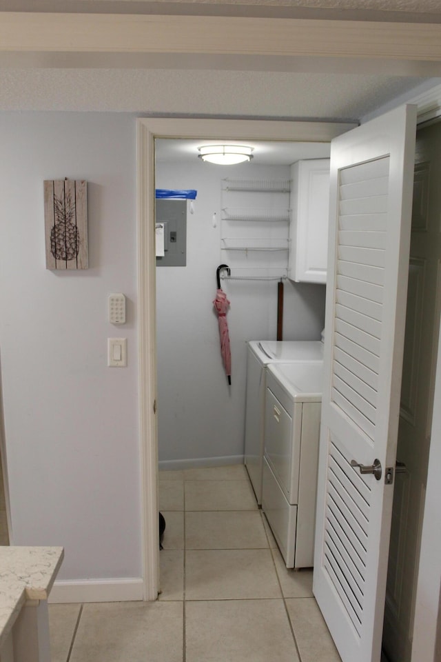 washroom featuring light tile floors, cabinets, and washing machine and dryer