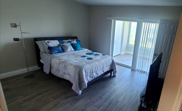 bedroom with vaulted ceiling and hardwood / wood-style flooring