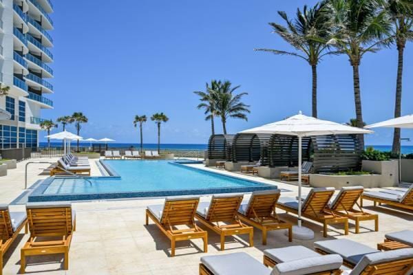 view of pool with a water view and a patio