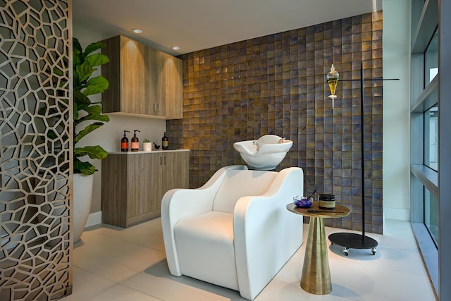 sitting room featuring light tile patterned floors and tile walls