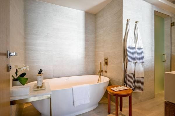 3100 N Ocean Dr Unit H-1509, Singer Island, FL 33404 - bathroom with a soaking tub, tile walls, and an enclosed shower