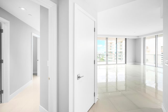 corridor featuring light tile patterned floors and floor to ceiling windows