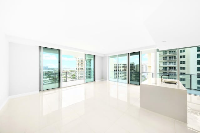 3100 N Ocean Dr Unit H-1509, Singer Island, FL 33404 - spare room with expansive windows, a view of city, tile patterned flooring, and baseboards