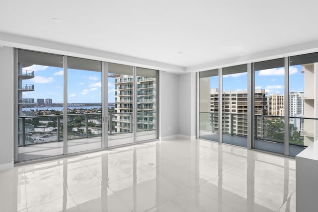 tiled spare room with expansive windows and a healthy amount of sunlight