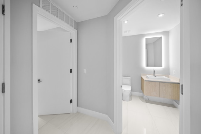 bathroom with tile patterned flooring, vanity, and toilet