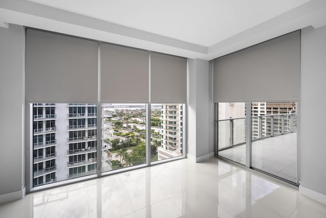 3100 N Ocean Dr Unit H-1509, Singer Island, FL 33404 - empty room featuring floor to ceiling windows, baseboards, a view of city, and tile patterned flooring