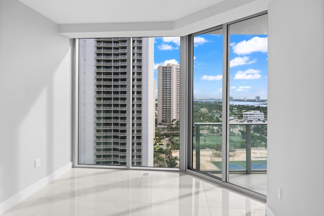 3100 N Ocean Dr Unit H-1509, Singer Island, FL 33404 - tiled spare room with a city view, baseboards, and a wall of windows
