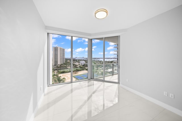 3100 N Ocean Dr Unit H-1509, Singer Island, FL 33404 - tiled spare room featuring baseboards, a view of city, and floor to ceiling windows