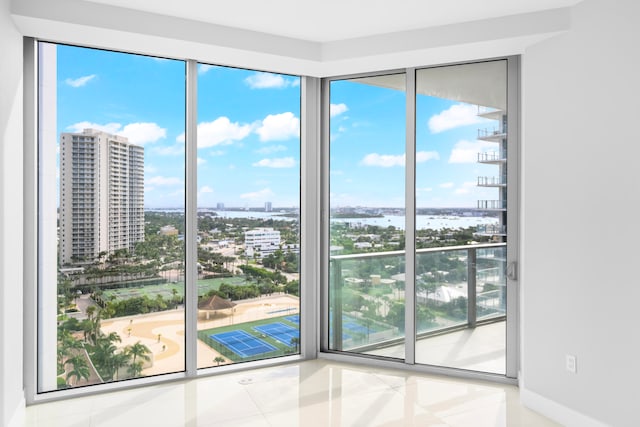 entryway featuring tile patterned flooring, a water view, and a healthy amount of sunlight