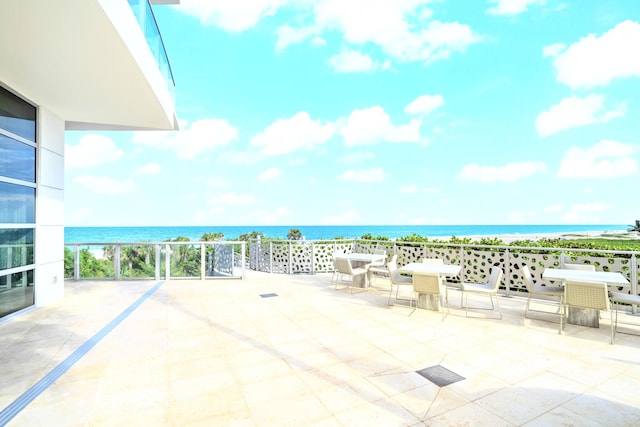 view of patio / terrace with a beach view and a water view