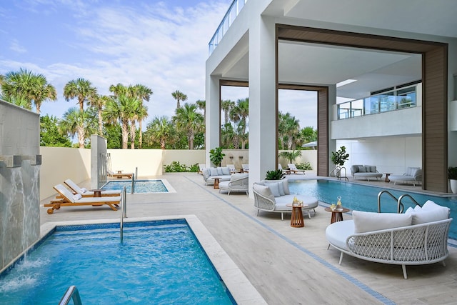 view of pool with outdoor lounge area, a patio area, and pool water feature