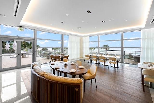 dining area with expansive windows, a healthy amount of sunlight, and a raised ceiling