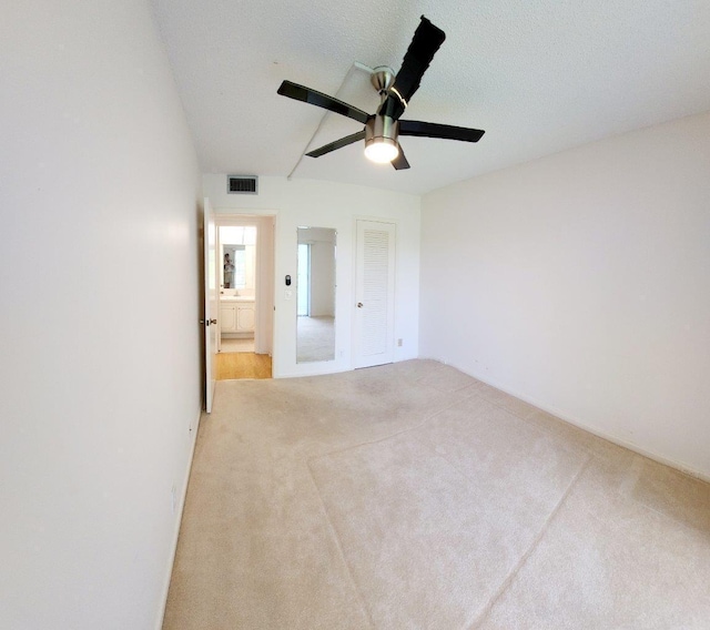 spare room featuring ceiling fan and light colored carpet