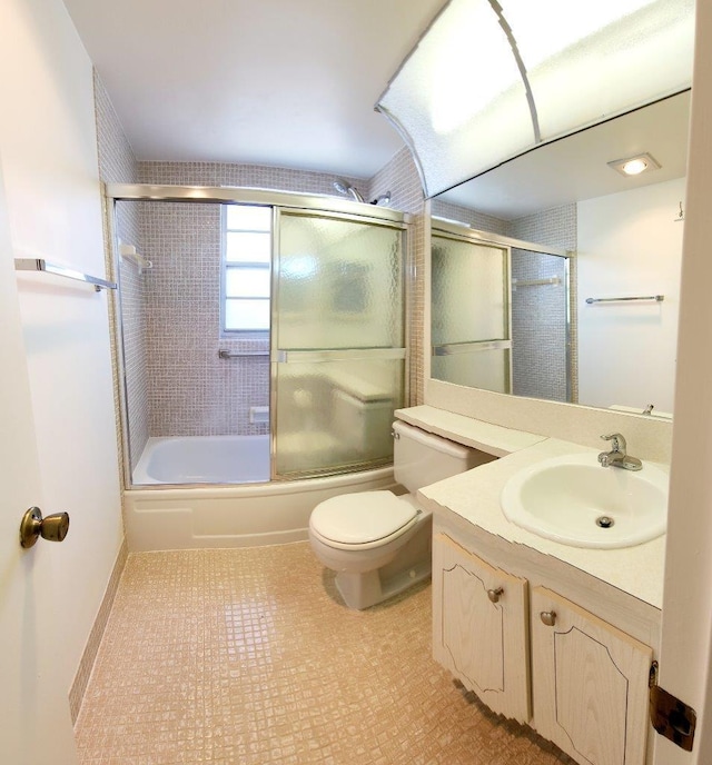 full bathroom featuring toilet, shower / bath combination with glass door, vanity, and tile flooring