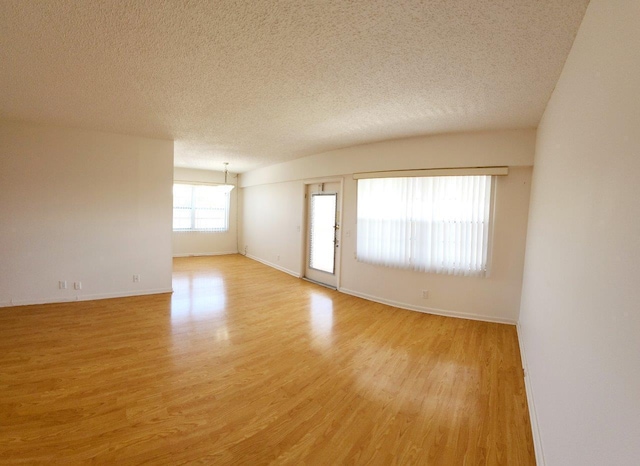 unfurnished room with a textured ceiling and light hardwood / wood-style flooring