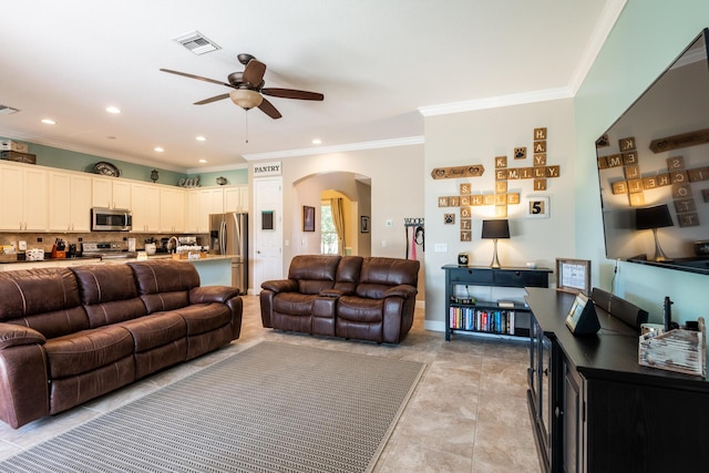 tiled living room with crown molding and ceiling fan