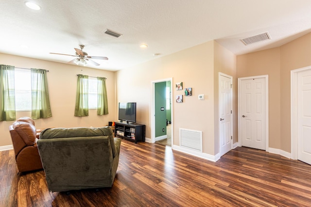 living room with ceiling fan and dark hardwood / wood-style flooring